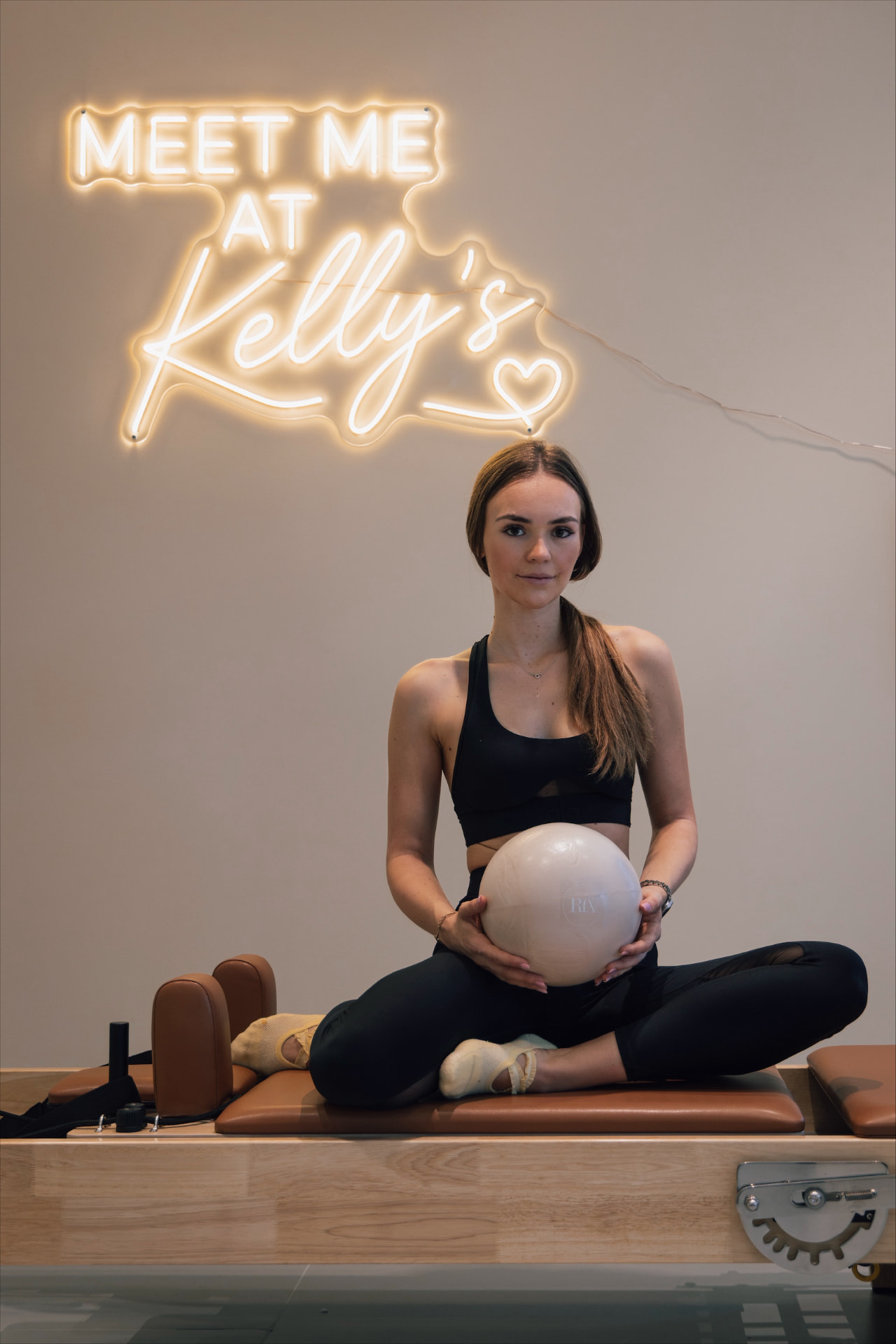 Alja z pilates žogo pod napisom Meet me at Kelly's